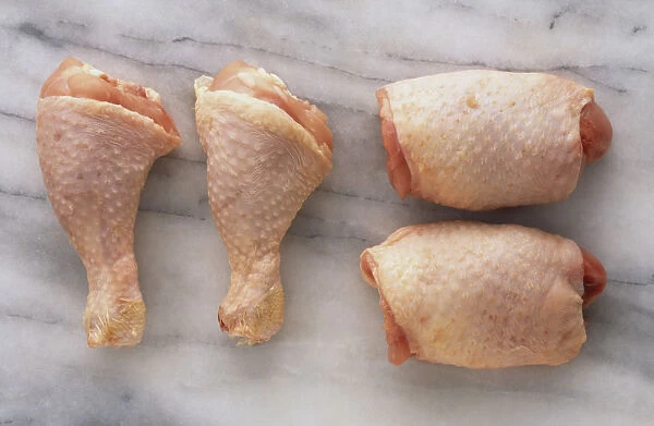 Chopped chicken legs on granite work surface, overhead view