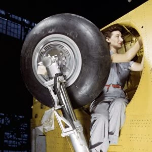 WWII: FACTORY, 1943. A woman working on the wheel well of a Vultee A-31 Vengeance