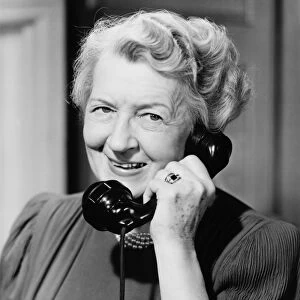Senior woman talking on telephone, (B&W)