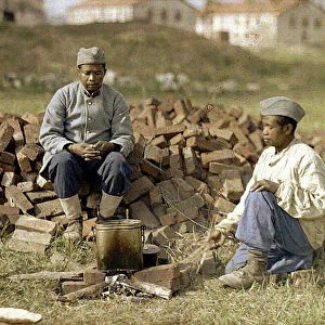Two African soldiers heating up a meal, Soissons, Aisne, France, 1917 (autochrome)